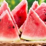 A bottle of watermelon seed oil with watermelon slices and seeds in the background.